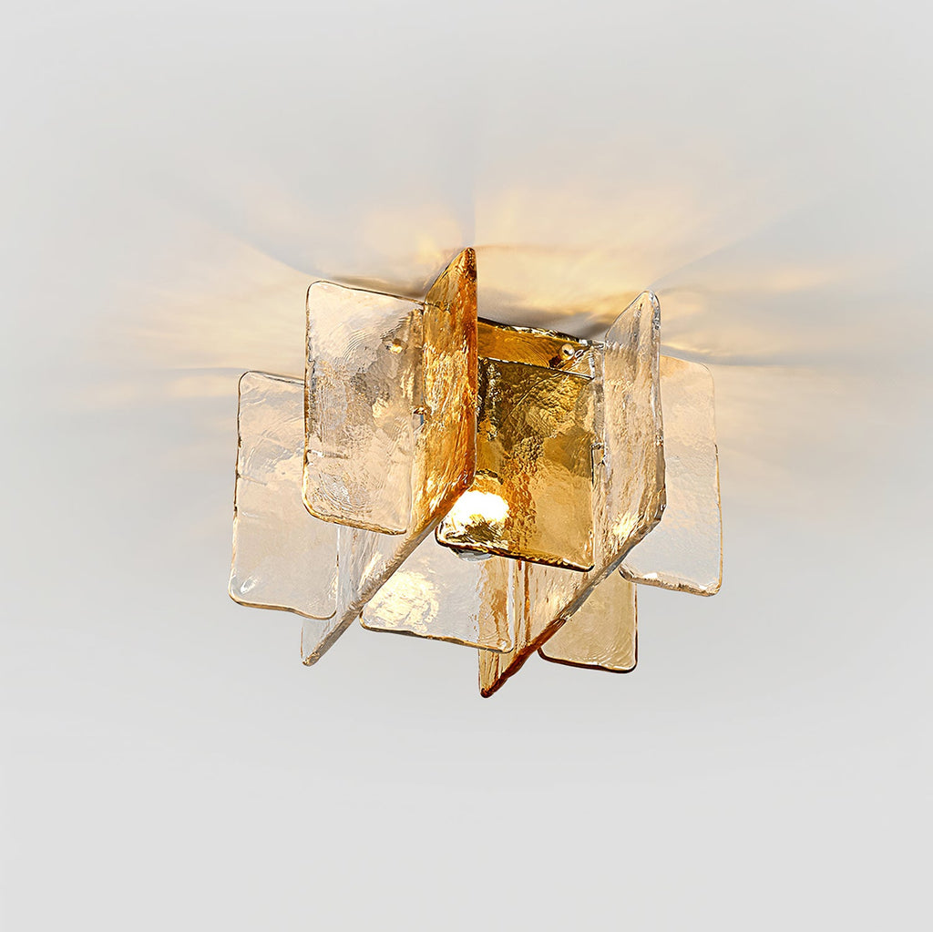 Angled view of this Clérachic ceiling light, with its textured amber and clear glass panes and the bulb glowing at the centre.