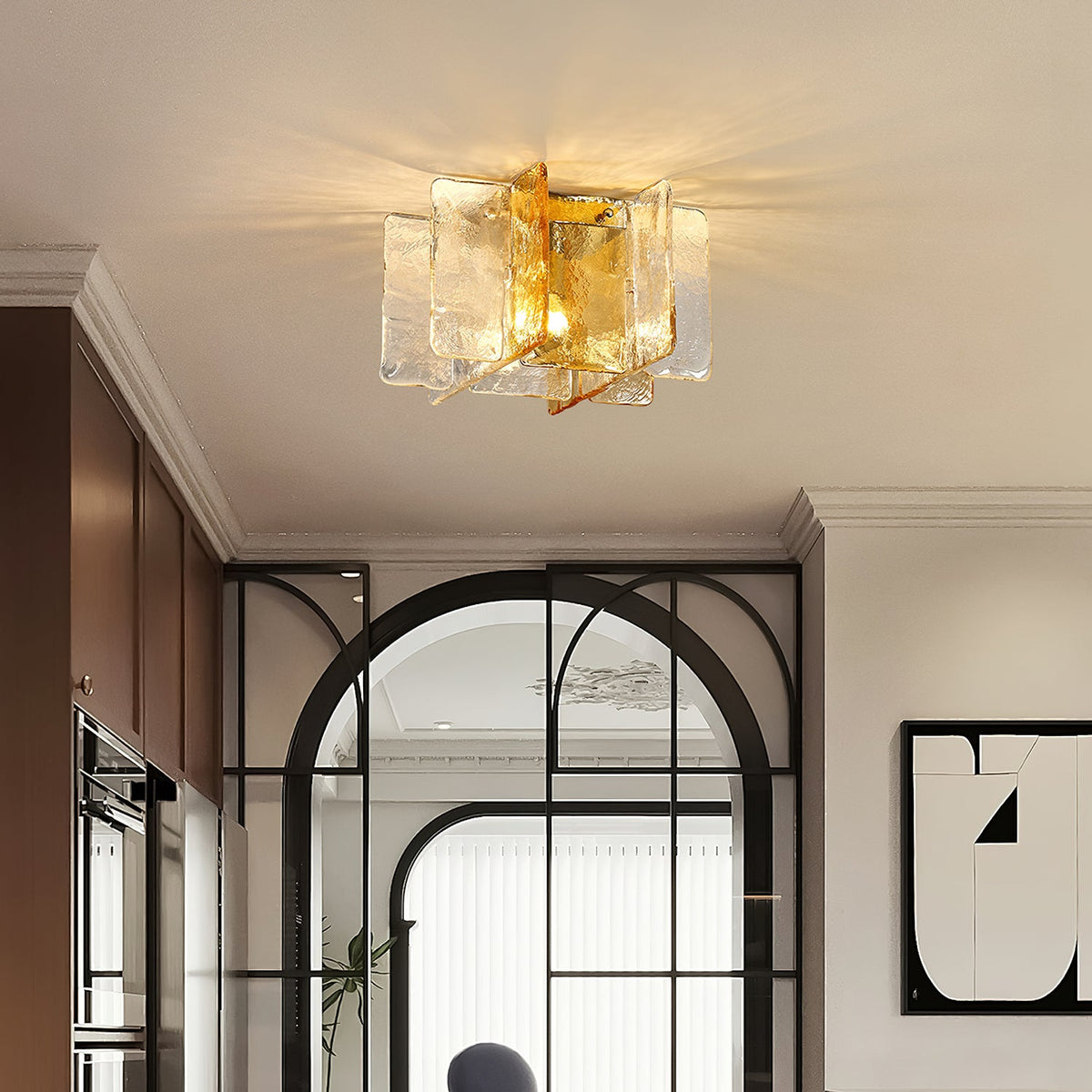 Clérachic glass-pane ceiling light lit in a corridor with an arched black-framed glass door, dark cabinets and a framed graphic print.