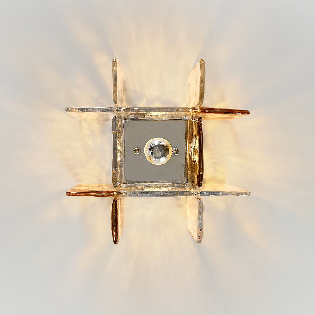 View from directly below at this Clérachic ceiling light, with its square metal base plate and bulb ringed by clear and amber glass panes.