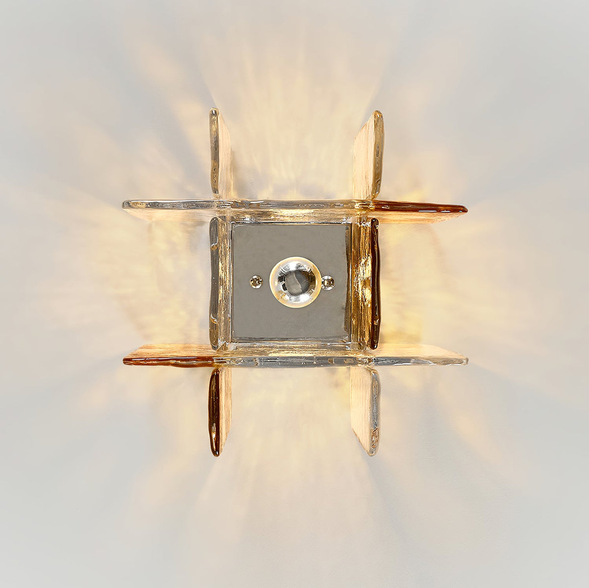 View from directly below at this Clérachic ceiling light, with its square metal base plate and bulb ringed by clear and amber glass panes.