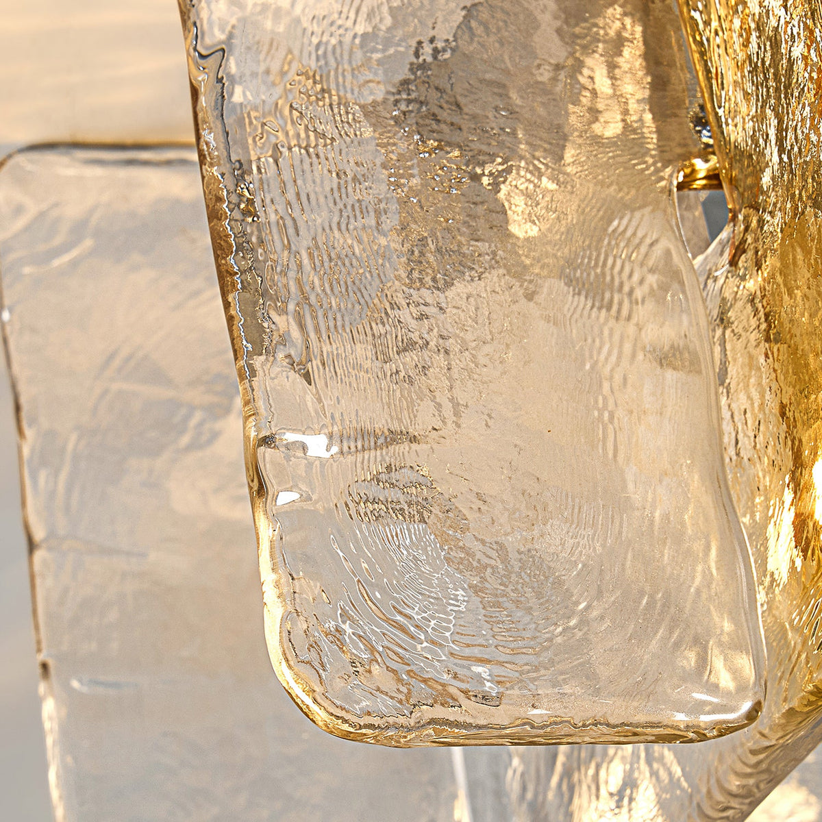 Close view of the rippled, textured surface of a clear glass pane edged with amber on this Clérachic ceiling light.