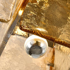 Close view of the amber glass pane and a silver-coated bulb tucked inside the frame of this Clérachic ceiling light.