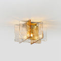 Lit Clérachic flush-mount ceiling light with clear and amber glass panes, sending a warm glow across a pale grey ceiling.
