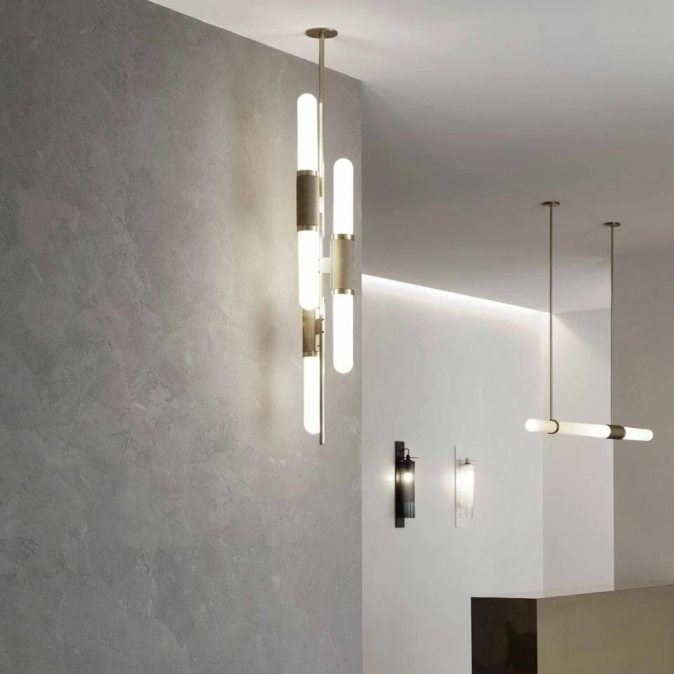 Vertical and horizontal versions of this Clérachic pendant light lit in a pale plaster hallway, with wall lights nearby.
