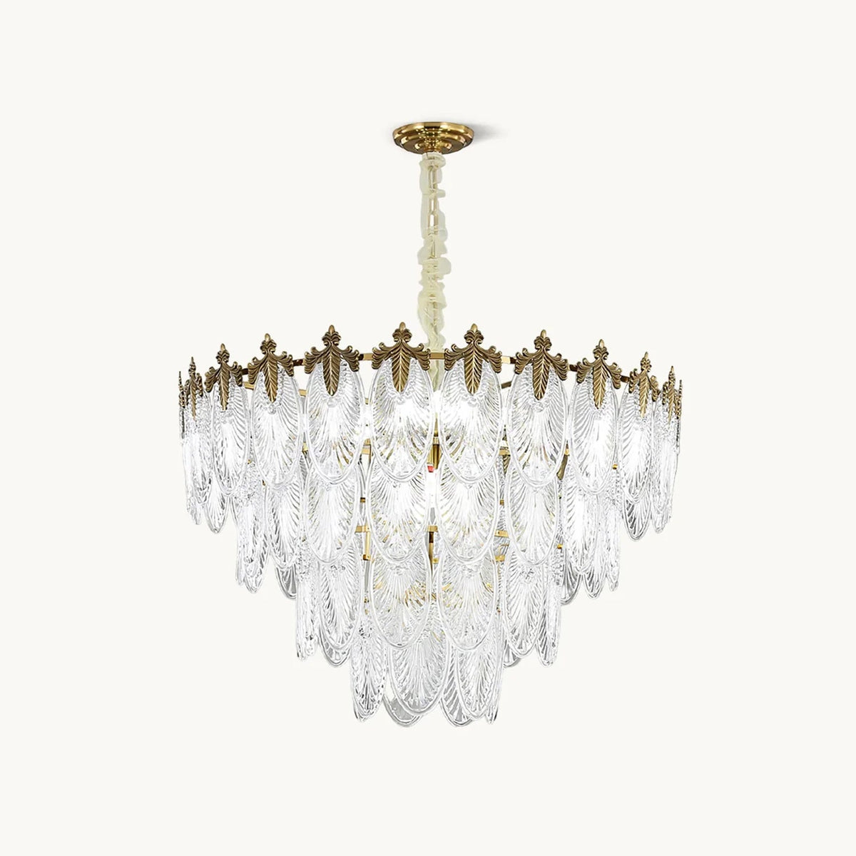 A Clérachic chandelier on a plain white backdrop, with overlapping clear glass leaf shades under a gold crown and a gold canopy on a chain.