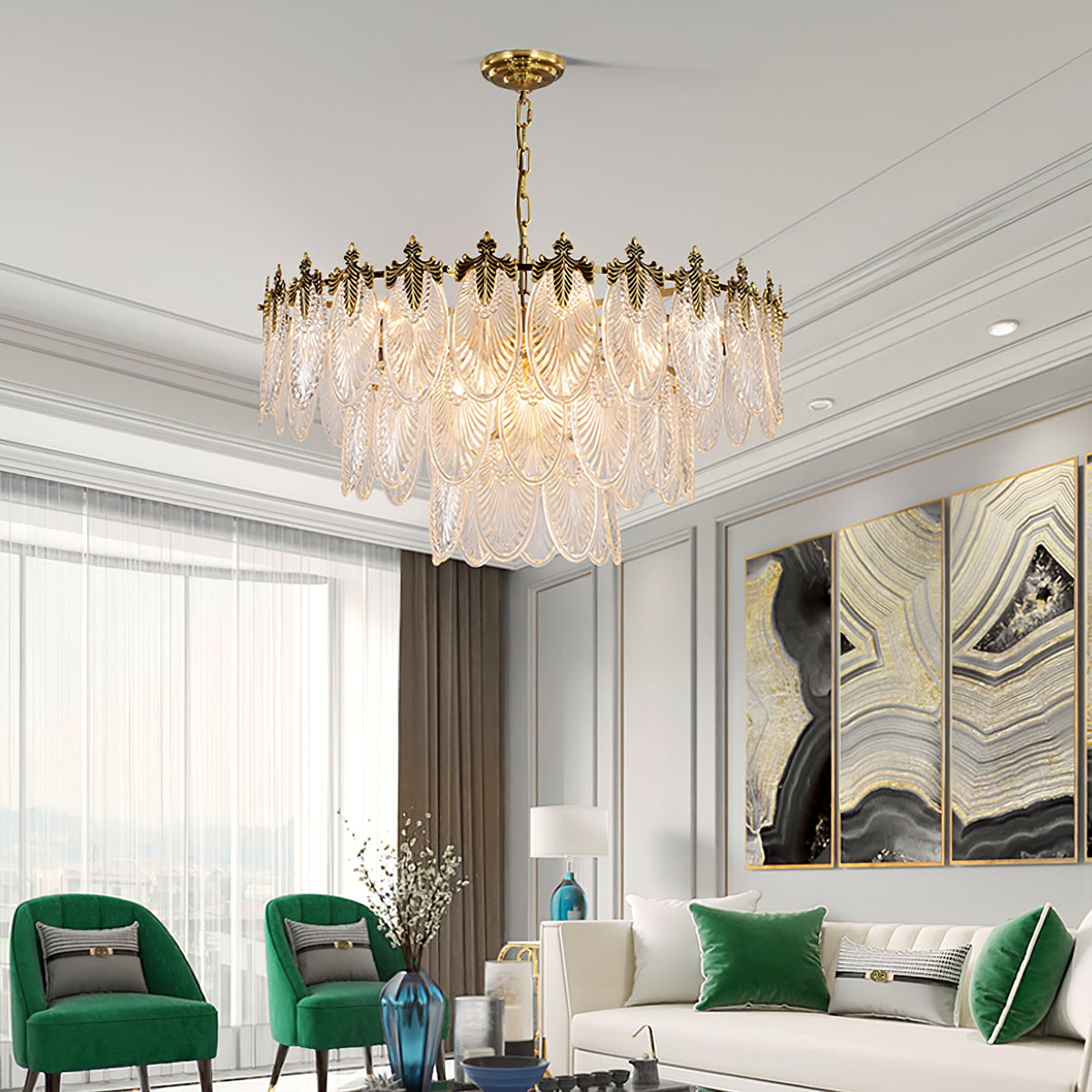 Lit Clérachic leaf chandelier hanging in a grey-panelled living room with green armchairs, a cream sofa and a large marble-patterned triptych.