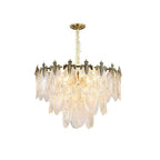 Cut-out of this Clérachic chandelier lit warm on white, its tiers of ribbed glass leaves below a gold crown and a gold canopy.
