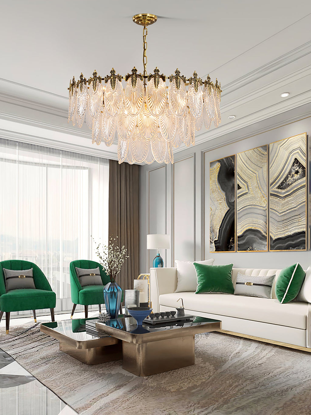 A Clérachic glass leaf chandelier in a bright room with green armchairs, a white sofa, a low glass table and a view through sheer curtains.