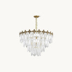Unlit Clérachic chandelier on a cream backdrop, with four stepped tiers of clear glass leaves under a gold crown and canopy.