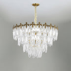 Unlit Clérachic chandelier on a grey backdrop, its glass leaves stepped in several tiers below the gold canopy and chain.