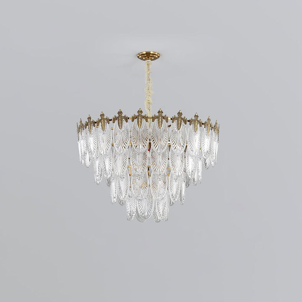 Mid-size three-tier Clérachic chandelier with clear glass leaves under a gold crown, hanging from a short chain on a light grey backdrop.