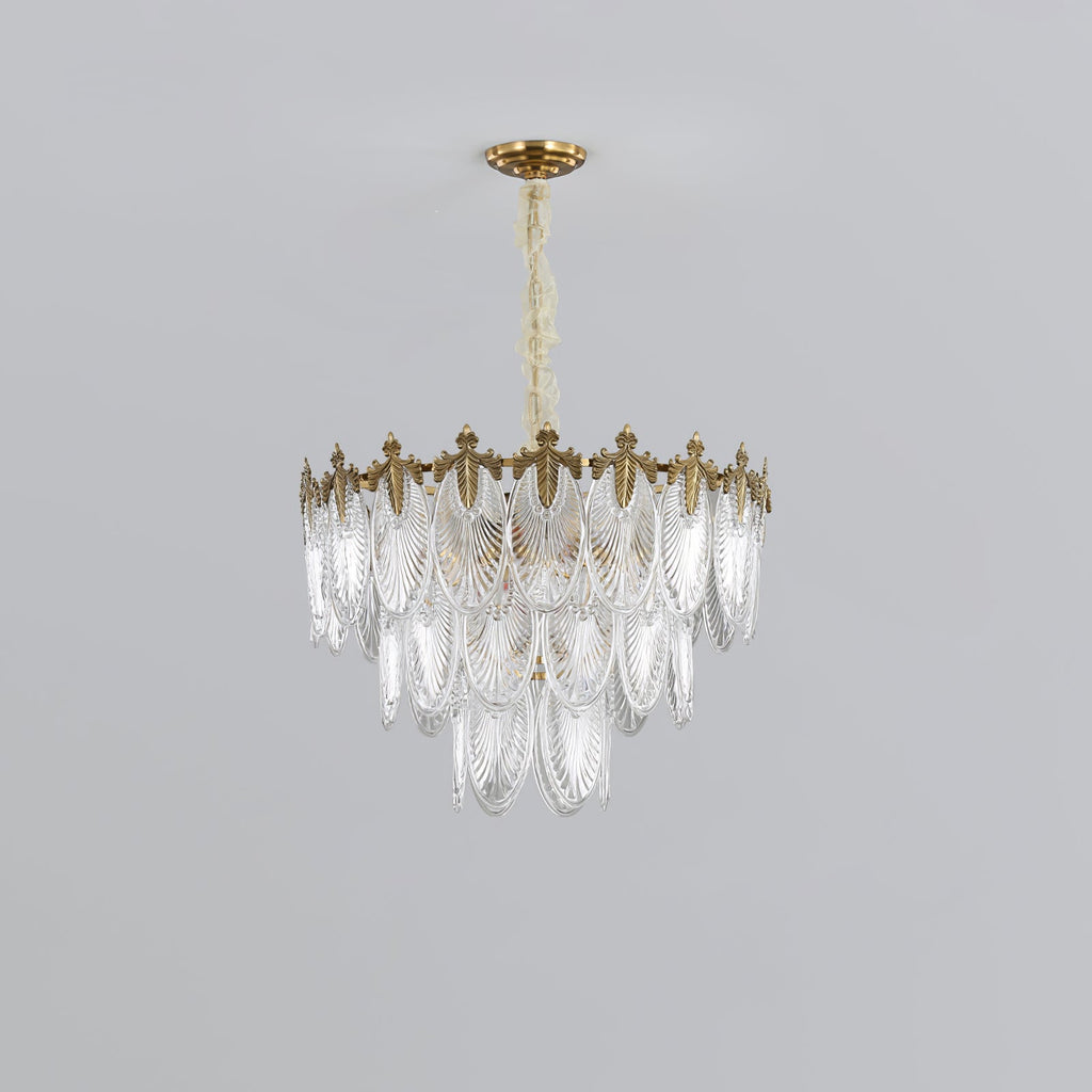 Compact three-tier Clérachic chandelier on a light grey backdrop, its glass leaves tapering below the gold crown, unlit.