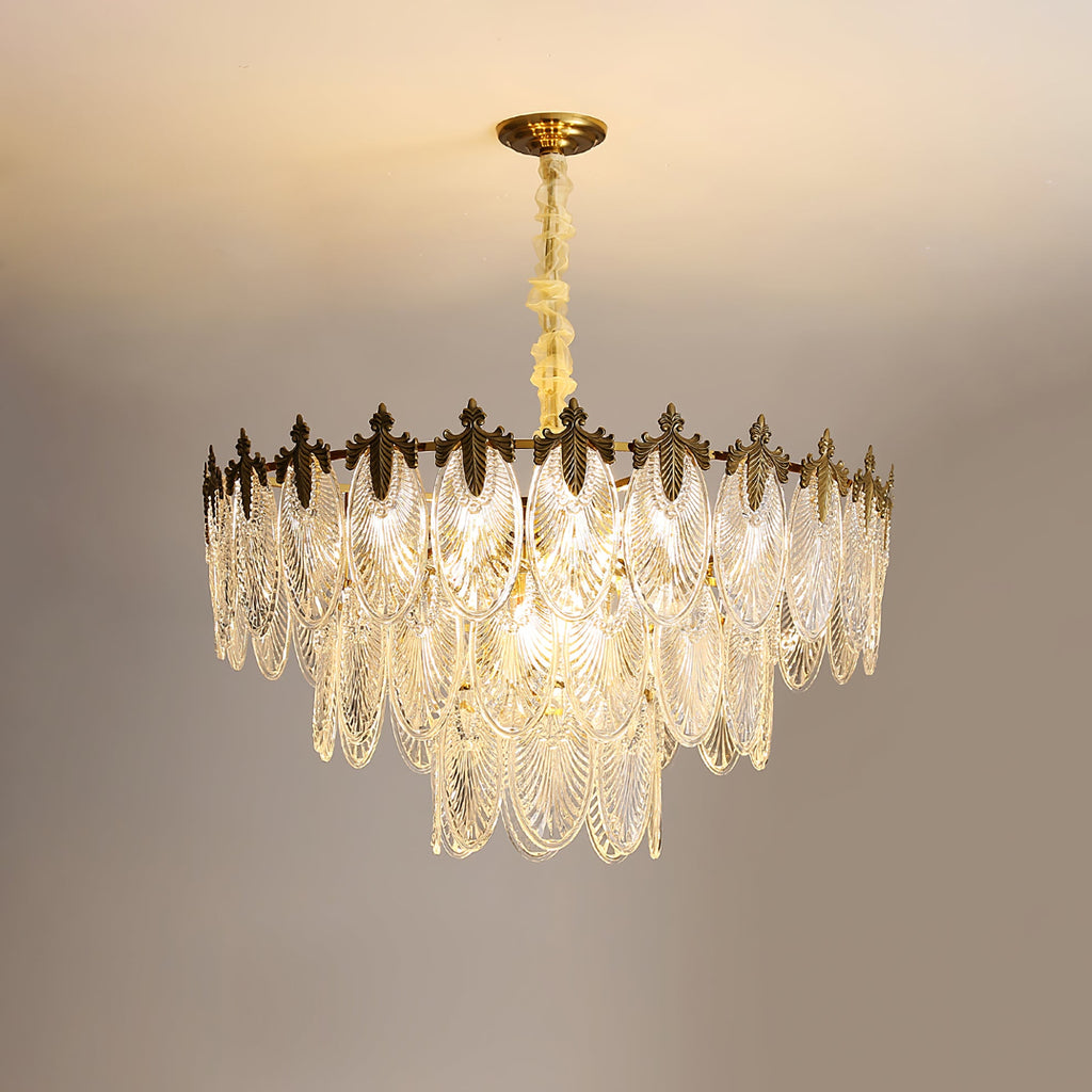 Lit Clérachic chandelier on a warm backdrop, its ribbed glass leaves catching light in tiers below the gold canopy.
