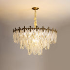 Lit Clérachic chandelier on a warm backdrop, its ribbed glass leaves catching light in tiers below the gold canopy.