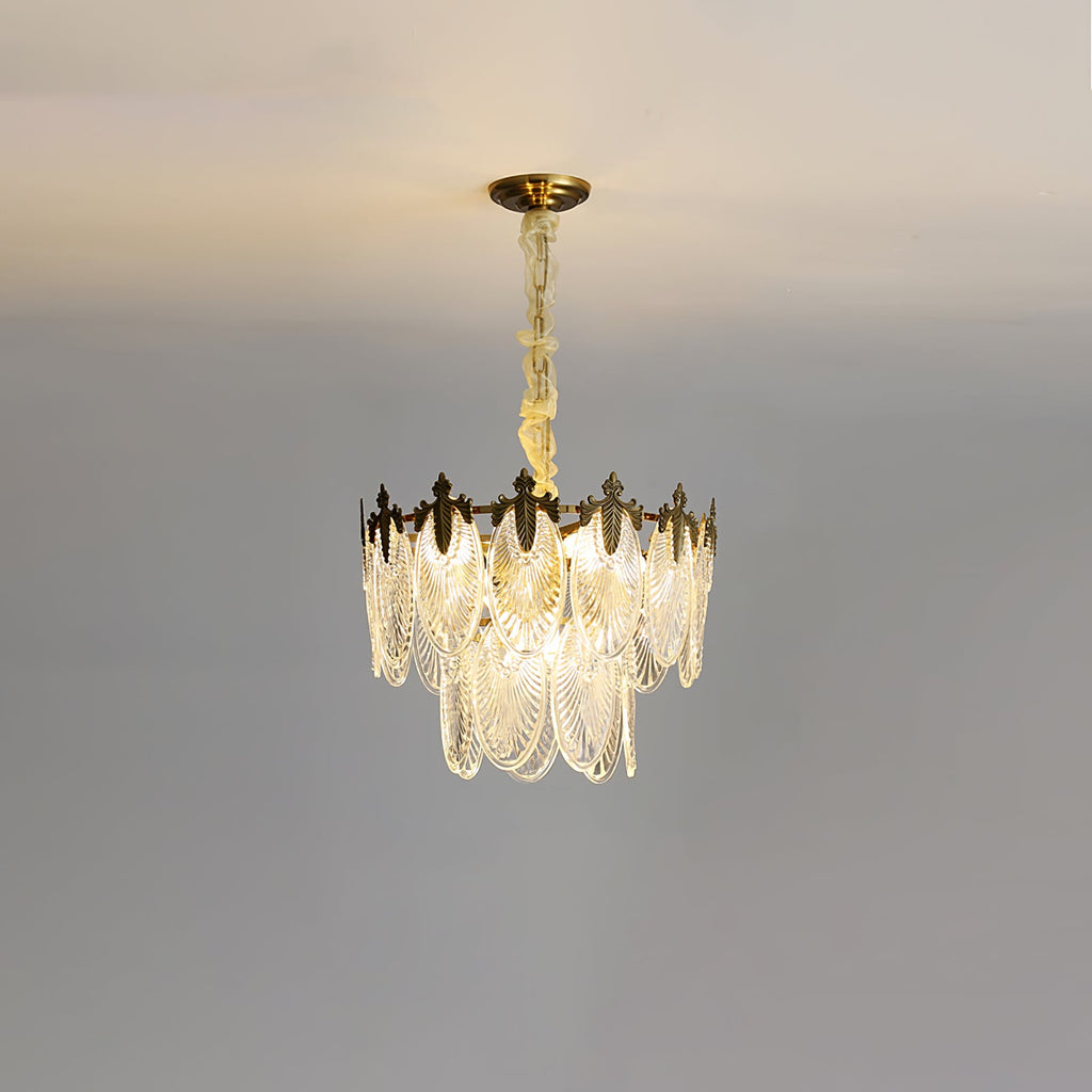 Lit compact Clérachic chandelier on a grey backdrop, with two tiers of glass leaves and a gold canopy above.
