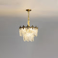 Lit compact Clérachic chandelier on a grey backdrop, with two tiers of glass leaves and a gold canopy above.