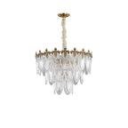 Unlit Clérachic chandelier on white, with tiers of clear ribbed glass leaves hanging from a gold crown on a pale chain.