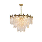 Softly lit Clérachic chandelier on white, its glass leaves glowing pale gold below a bronze-toned crown and a gold canopy.