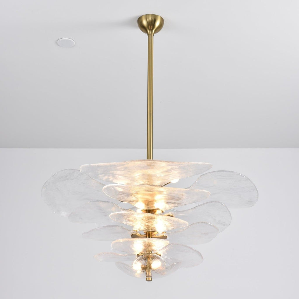Clear Clérachic petal chandelier on a long brass rod, with lit bulbs showing through the rippled glass tiers.