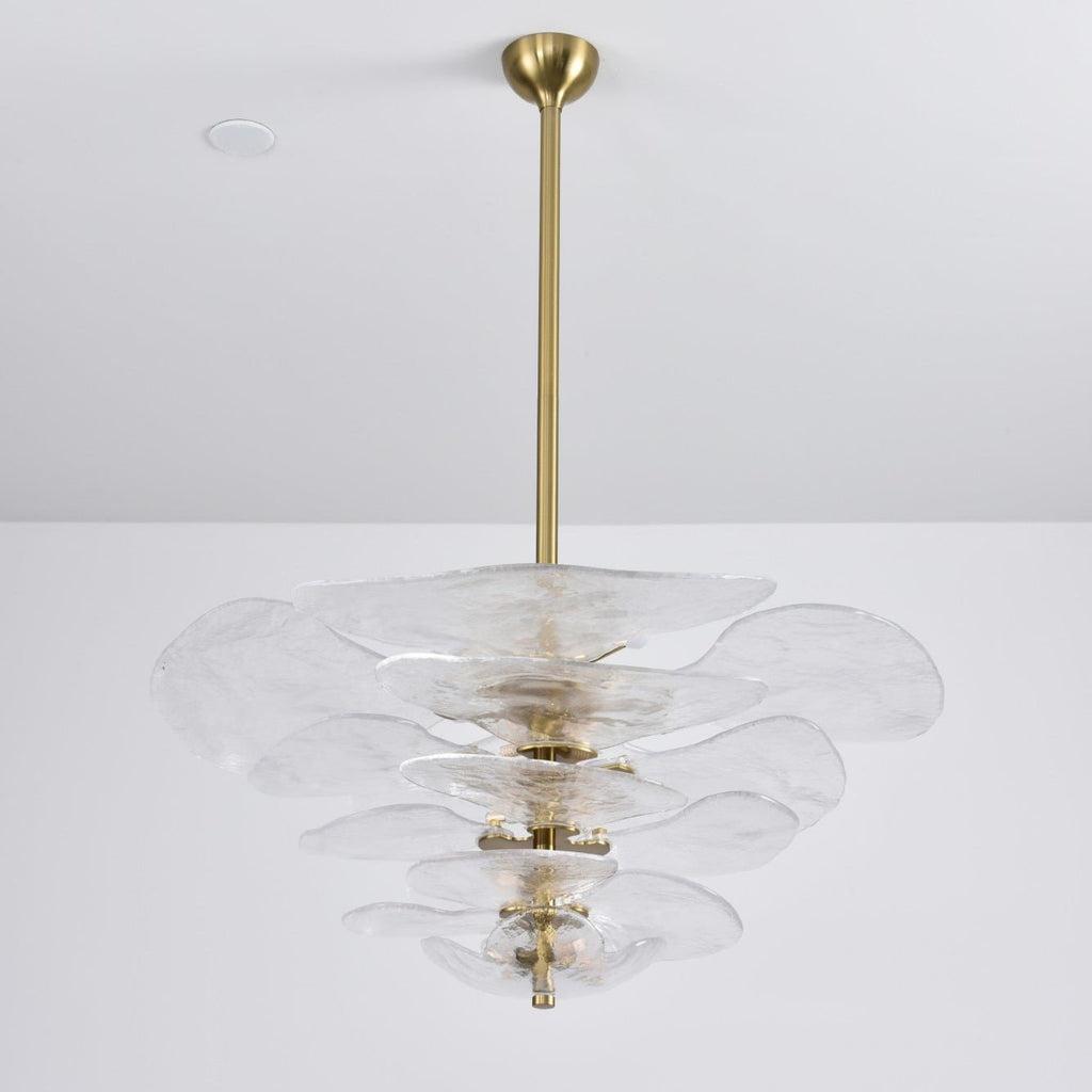 Unlit clear glass Clérachic chandelier on a long brass rod, its rippled petals stacked and a brass spindle visible in the centre.