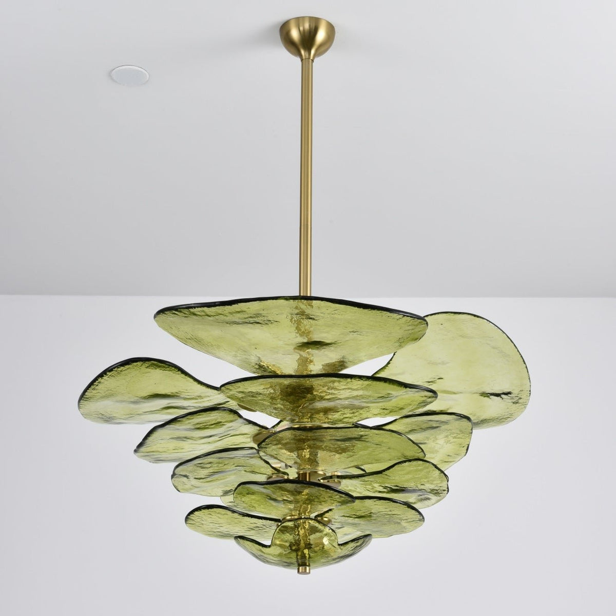 Unlit green Clérachic chandelier on a long brass rod, with large olive petals spreading out in uneven tiers on a grey backdrop.