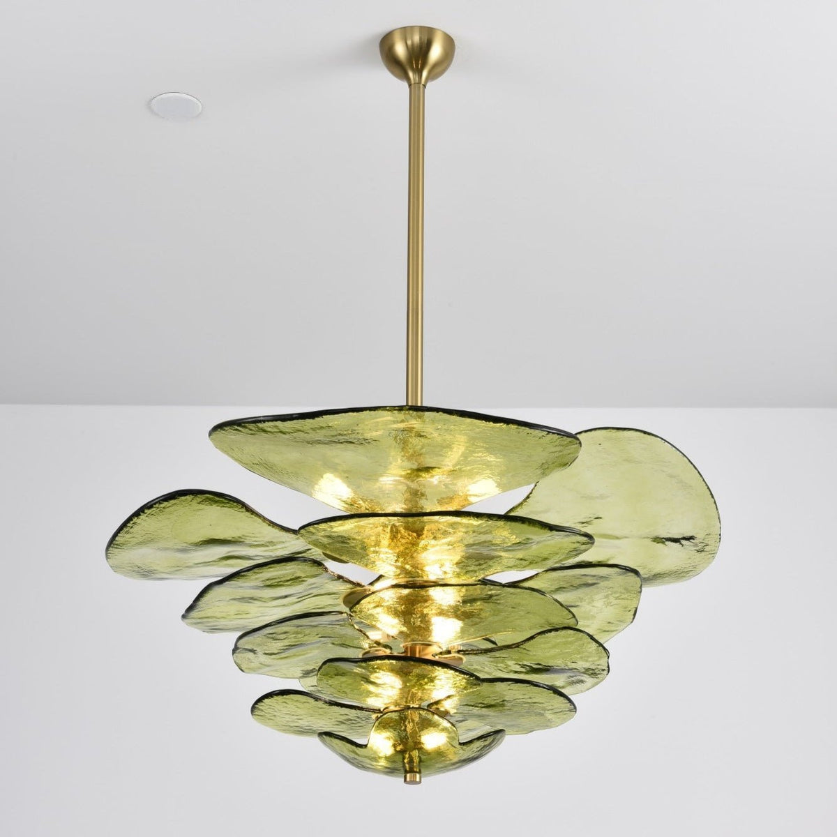 Lit green Clérachic chandelier on a long brass rod, its olive petals glowing from the bulbs inside the tiers.