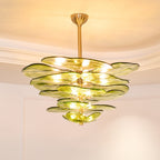 Wide green Clérachic chandelier lit beneath a coved ceiling, its broad olive petals spreading in layers around a brass rod.