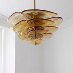 Amber Clérachic chandelier with gold fittings seen from below, its pale honey glass petals overlapping around a brass rod.