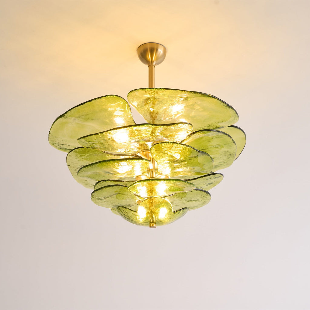 Lit green Clérachic chandelier on a warm-toned ceiling, with bulbs glowing between its olive glass petals.