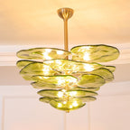 Large lit green Clérachic chandelier seen from below, its overlapping olive petals reaching out in broad layers.