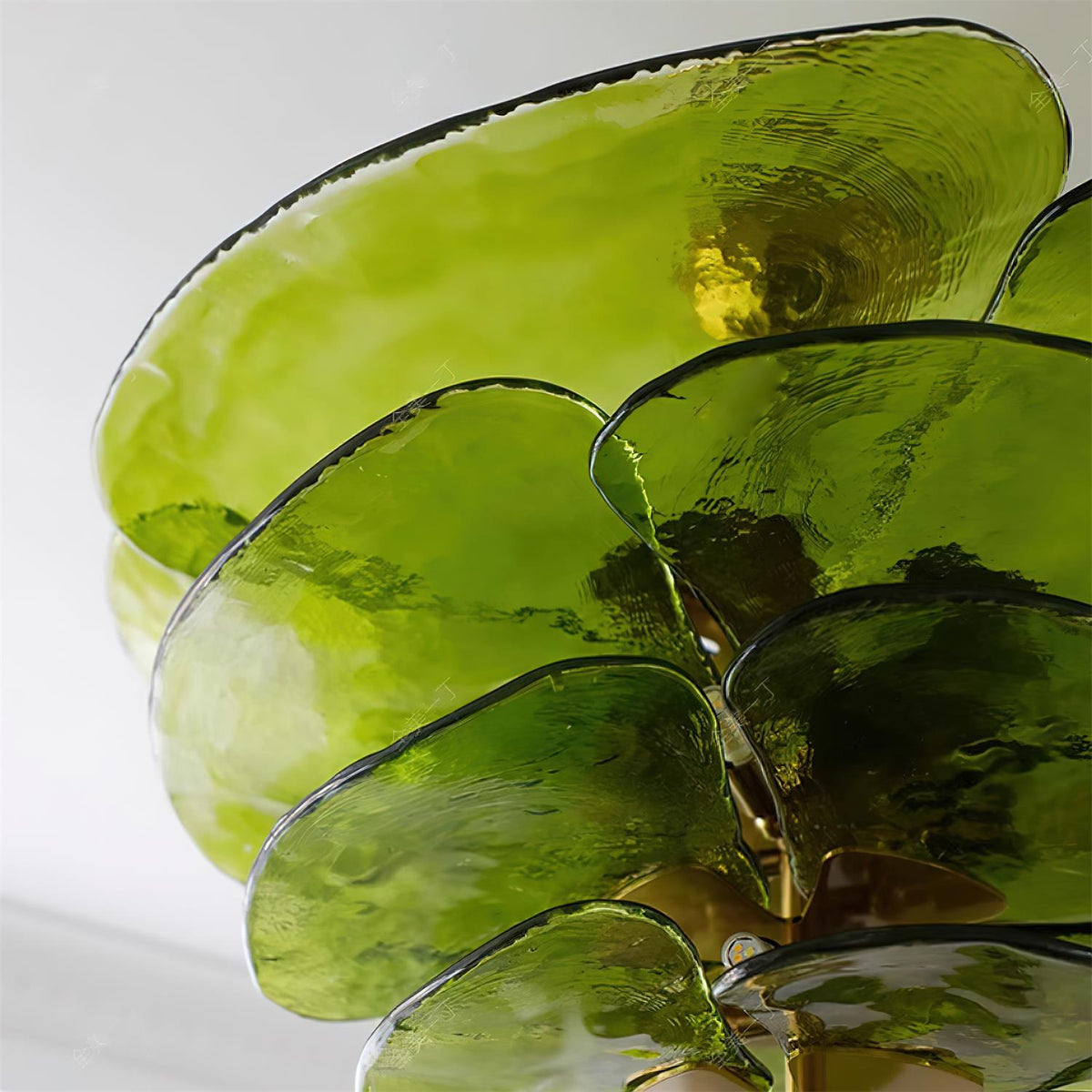 Close view of overlapping olive glass petals on this Clérachic chandelier, with a hint of the brass fitting at the centre.