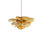 Compact amber Clérachic chandelier on white, with light gold glass petals fanned out around brass spacers.