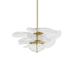 Clear glass Clérachic chandelier on white, with pale petals fanned out on brass spacers around a thin rod.
