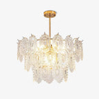 Clérachic gold-framed pendant with tiers of clear, diamond-textured glass shades, lit and shown on a plain white backdrop.