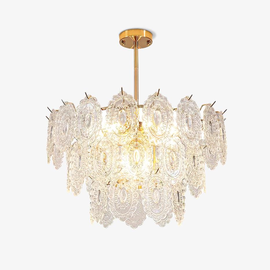 Clérachic gold-framed pendant with tiers of clear, diamond-textured glass shades, lit and shown on a plain white backdrop.