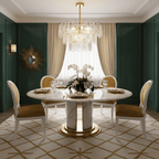 A Clérachic glass pendant on a gold stem above a round white marble dining table, set against green panelling and a sunburst mirror.