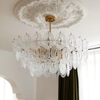 Looking up at the clear, patterned glass panels of this Clérachic pendant, beneath a carved ceiling rose and a dark green curtain.