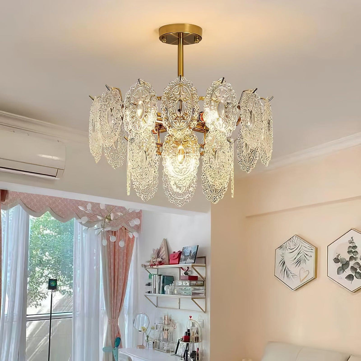 Clérachic gold and glass pendant under a flat ceiling, with an air-conditioning unit, pale pink curtains and shelves in a bright room.