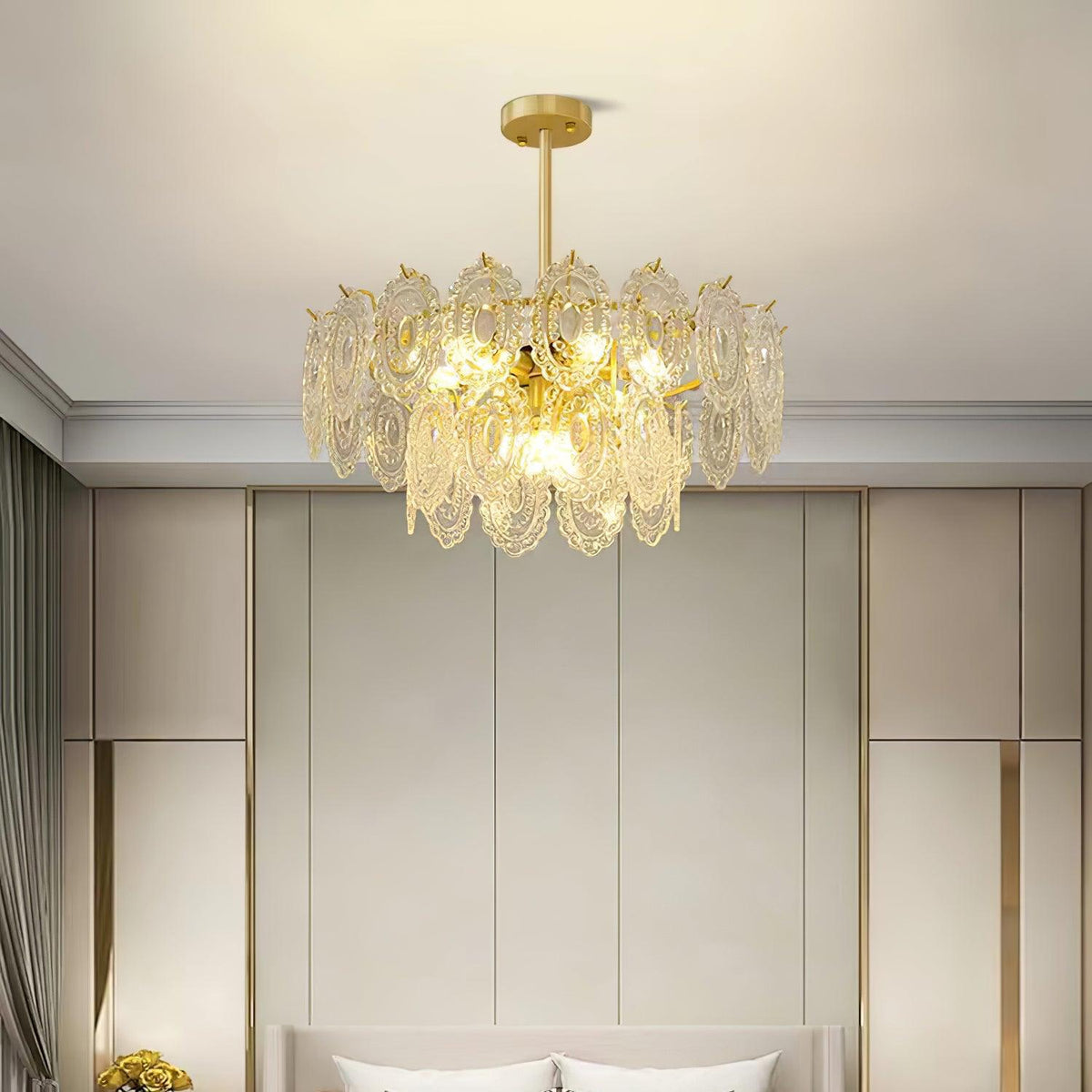 Lit Clérachic pendant centred in a bedroom with tall beige wall panels, above the top of a cream headboard.