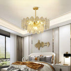 This Clérachic pendant hangs in a bedroom with a cove-lit ceiling, above a bed with grey cushions and a rust-coloured throw.