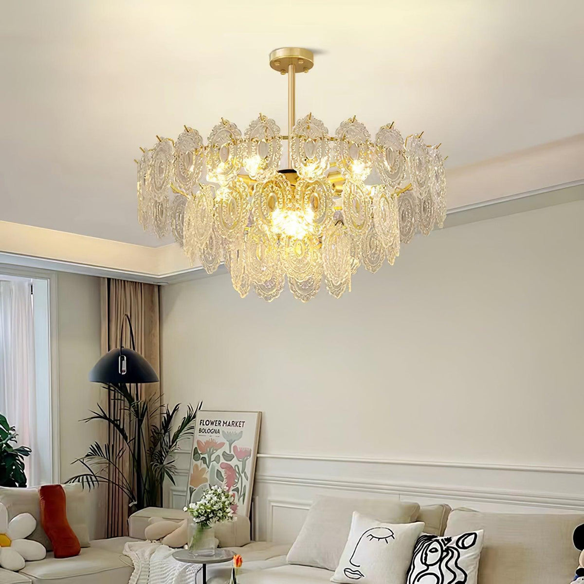 Clérachic glass pendant lit in a calm lounge, with a black floor lamp, a framed print and bright cushions below.