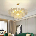 A Clérachic pendant with patterned clear glass hangs in a room with a green velvet sofa and a framed wing print behind.