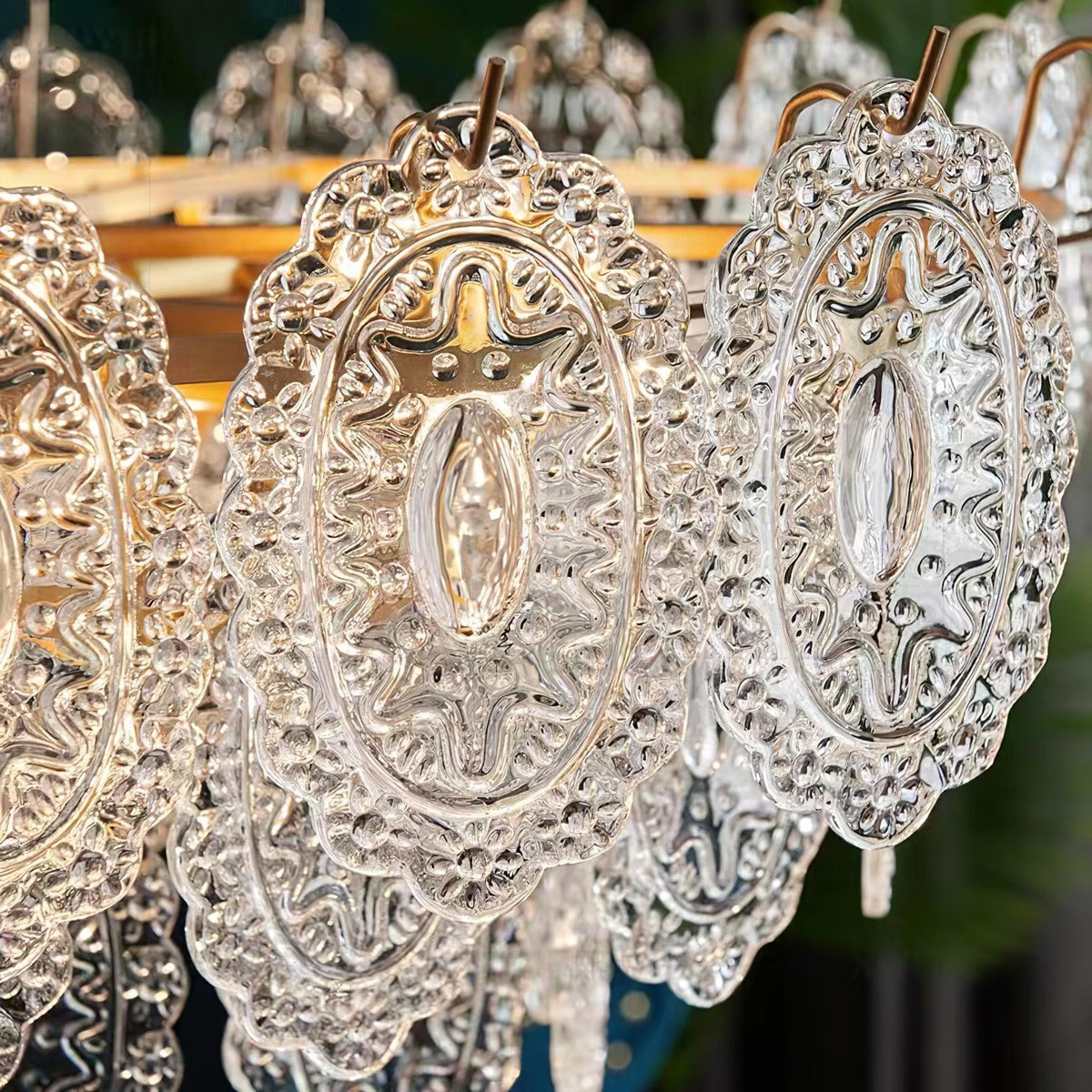 Close view of the diamond-textured, oval glass panels and wire hooks on this Clérachic pendant, lit from inside.