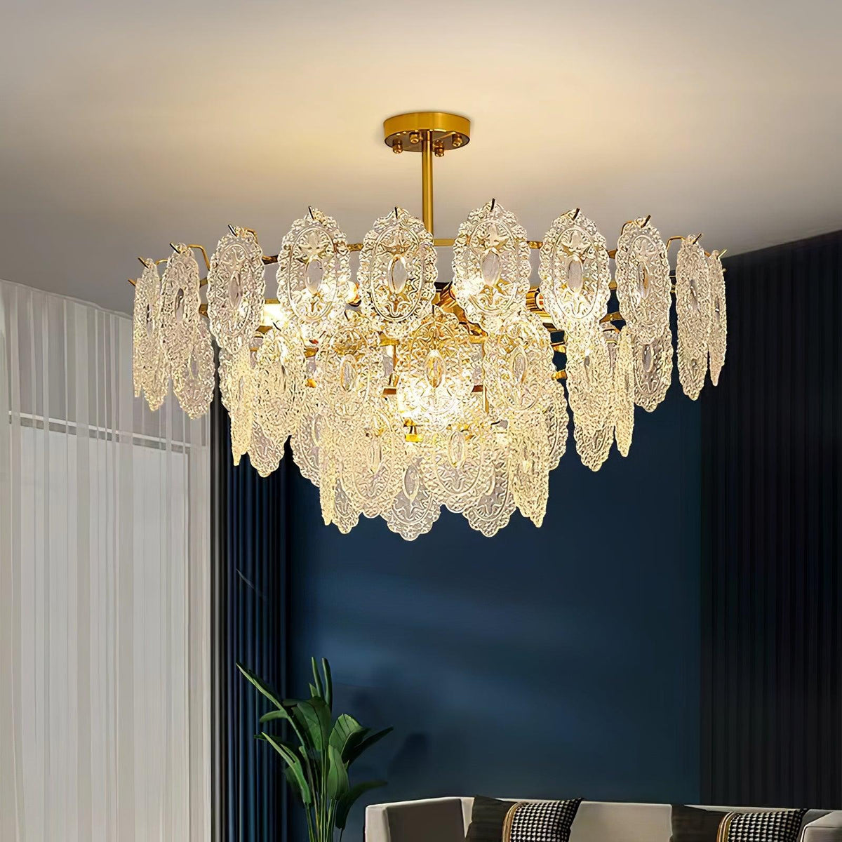 Wide Clérachic glass pendant in a living room with a deep blue wall, white sheer curtains and a plant in the corner.