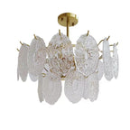 Close-up of the oval, patterned clear glass panels and gold hooks on this unlit Clérachic pendant, on a white backdrop.