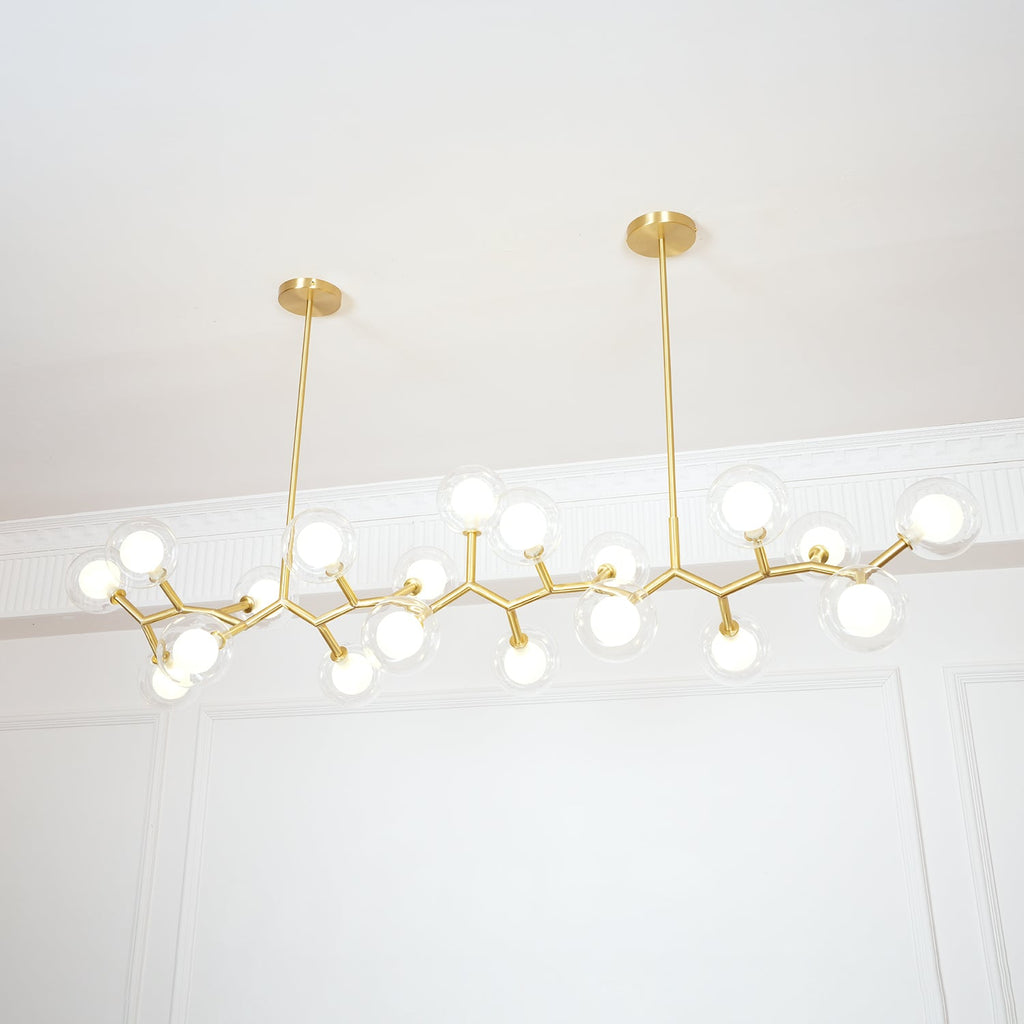 Lit Clérachic chandelier from below, its glowing globes and gold branches hung from two rods against white wall panelling.