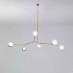 Small Clérachic gold-branch chandelier with six glass globes lit, hung from one long rod against a soft grey backdrop.