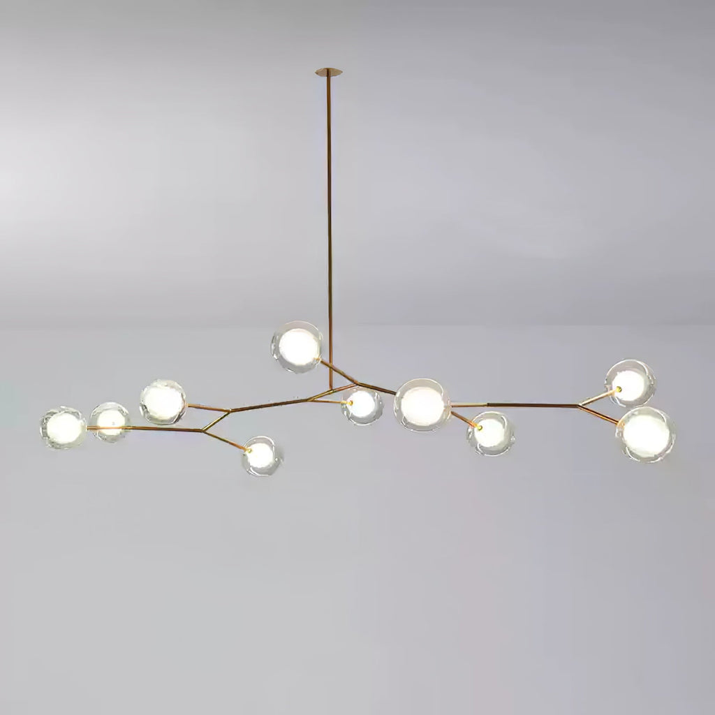 Medium Clérachic gold-branch chandelier with around ten lit glass globes, hung from a single long rod on a grey backdrop.