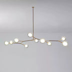 Medium Clérachic gold-branch chandelier with around ten lit glass globes, hung from a single long rod on a grey backdrop.