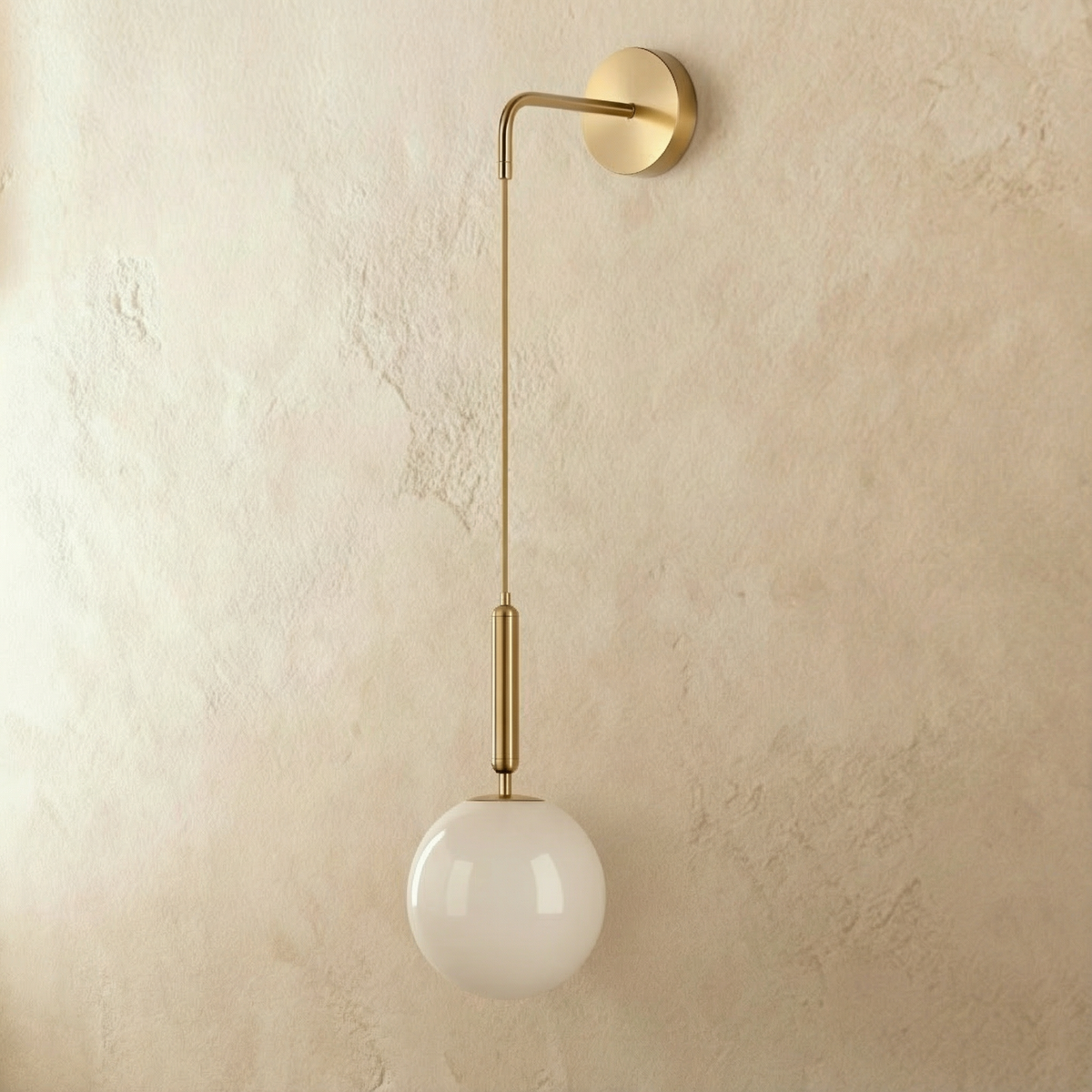 Clérachic gold globe wall sconce shown straight on, opal glass globe suspended below a jointed brass arm.